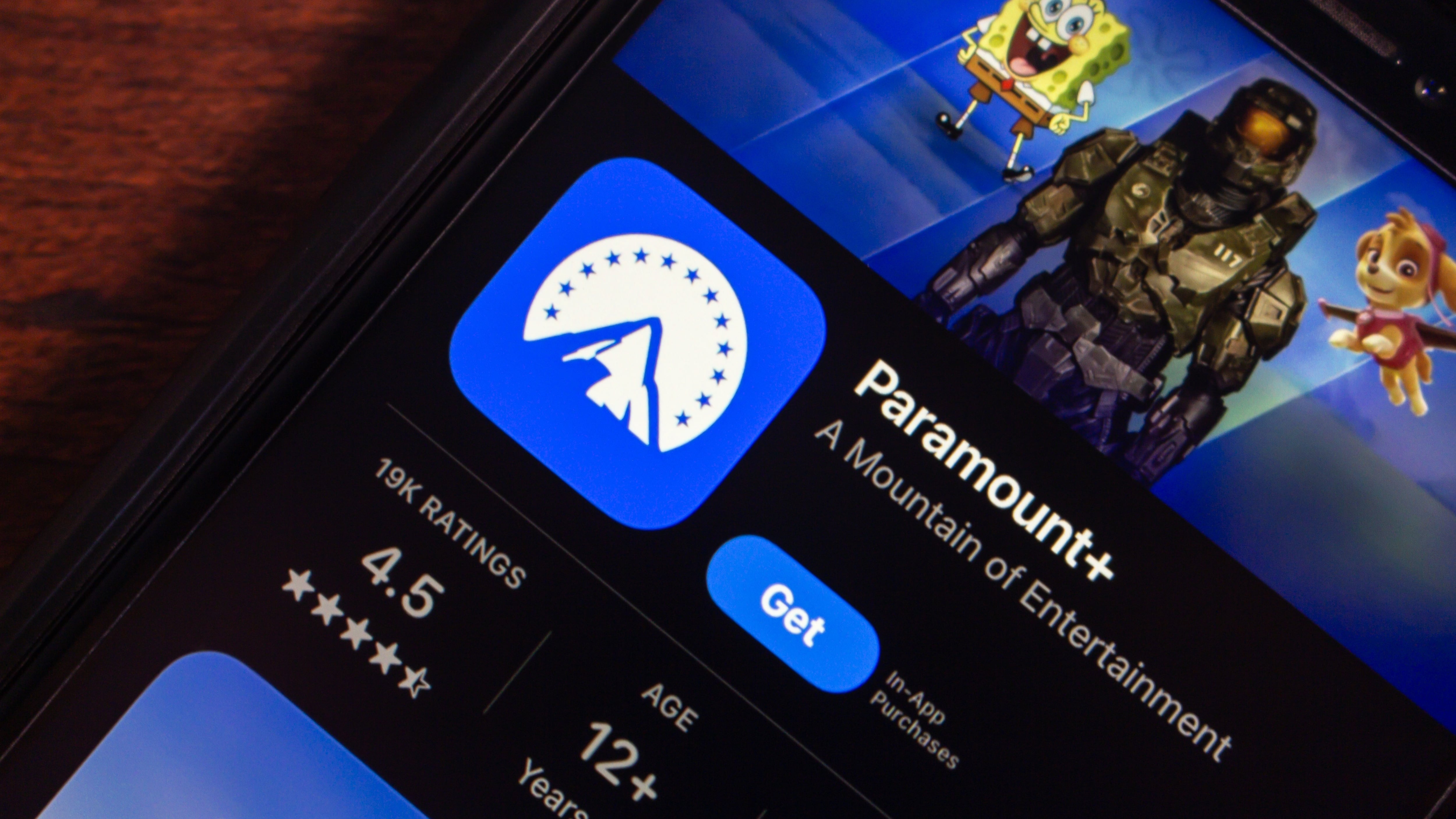 Smartphone displaying Paramount+ app store page, highlighting streaming entertainment services.