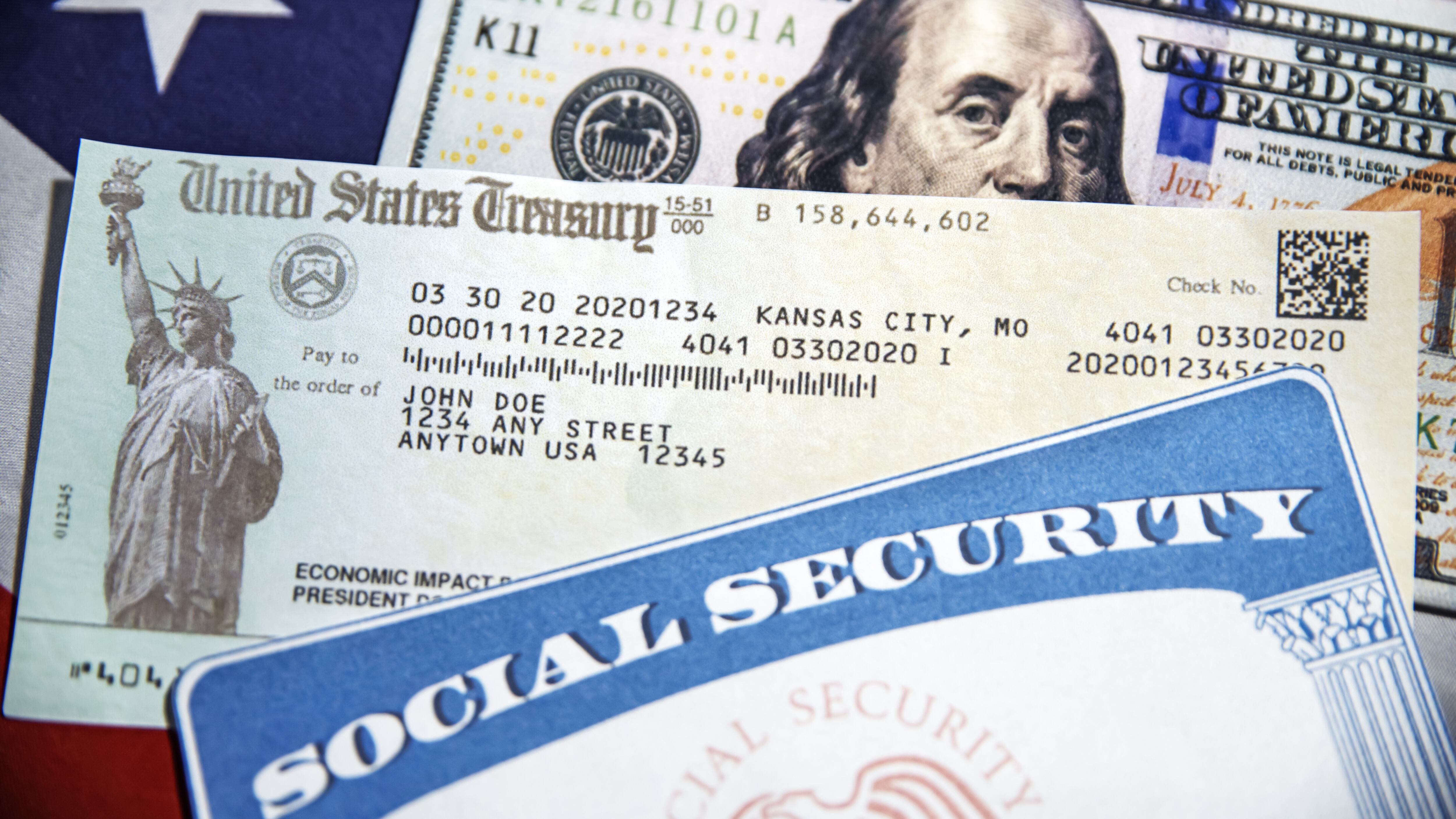 U.S. Treasury check, SSN and American dollar bill with flag in the backdrop, close up. Social Security card and treasurey check concept background