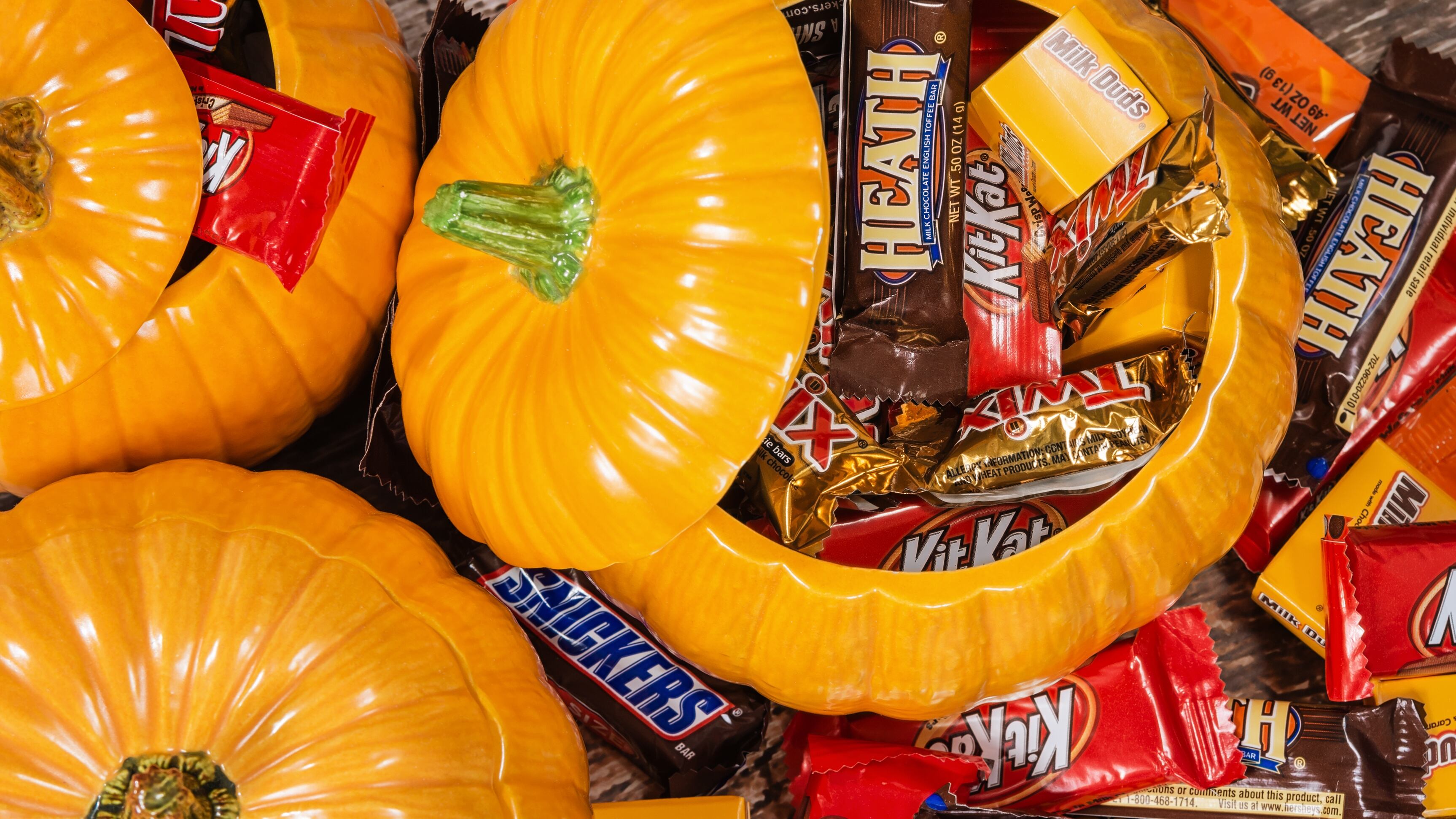 Decorative pumpkins filled with assorted Halloween chocolate candy made by Mars, Incorporated and the Hershey Company.